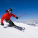 Narciarz w czerwonym ubraniu na stoku narciarskim. - Traveligo Blog