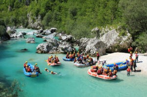 Grupa ludzi na pontonach, rafting Soca - Traveligo Blog