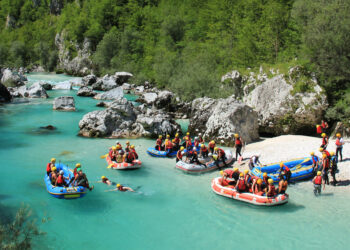 Grupa ludzi na pontonach, rafting Soca - Traveligo Blog