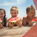 Dzieci biorące melonów na plaży - Traveligo Blog
