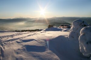 Ośnieżona góra, ciepłe światło słońca. Traveligo Blog