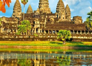 Widać starożytną świątynię Angkor Wat z Kambodży odbijającą się w wodzie. Traveligo Blog