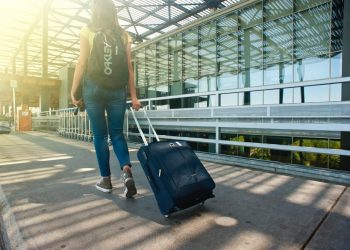 Kobieta z walizką na lotnisku - Traveligo Blog