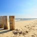 Drewniane pale na piaszczystej plaży nad Morzem Bałtyckim. Traveligo Blog
