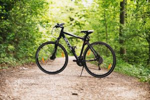 Czarny rower szosowy na leśnej ścieżce. - Traveligo Blog