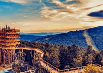 Drewniana wieża widokowa na tle gór. Traveligo Blog