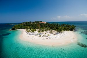 Tropikalna wyspa z białą piaszczystą plażą otoczoną turkusową wodą i palmami. Traveligo Blog