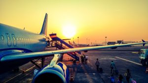 Samolot na lotnisku w letnim zachodzącym słońcu. Traveligo Blog