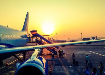 Samolot na lotnisku w letnim zachodzącym słońcu. Traveligo Blog