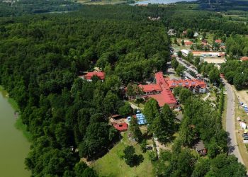 Rozległa zielona okolica z budynkami. Traveligo Blog