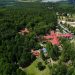 Rozległa zielona okolica z budynkami. Traveligo Blog