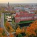 Stary, pomarańczowy zamek na tle jesiennej przyrody. Traveligo Blog