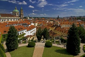 Piękny ogród Vrtbovski z krzewami i ścieżkami. Panorama Pragi ze strzelistymi wieżami. Traveligo Blog