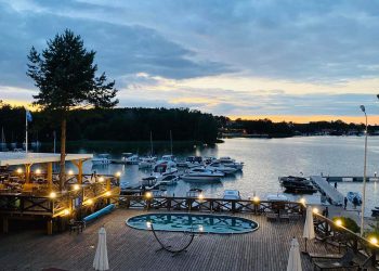 Drewniany pomost, łodzie, zachodnie słońce - Traveligo Blog