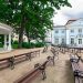 Zielone drzewa, zabytkowy budynek, ławki - Traveligo Blog