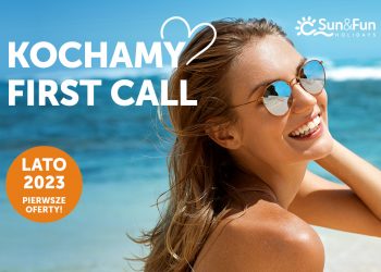 Kobieta w okularach przeciwsłonecznych, uśmiechnięta, na tle morza i plaży. Traveligo Blog