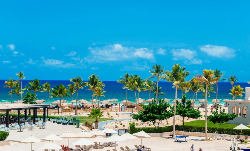 Widok na hotel Rotana Salalah Resort z palmami, plażą i turkusowym oceanem w tle