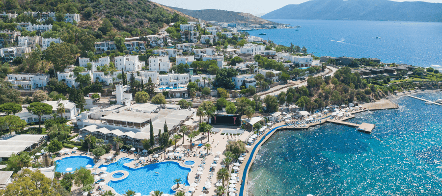 Panoramiczny widok na Bodrum z nadmorskimi hotelami, basenami i turkusowym wybrzeżem Morza Egejskiego