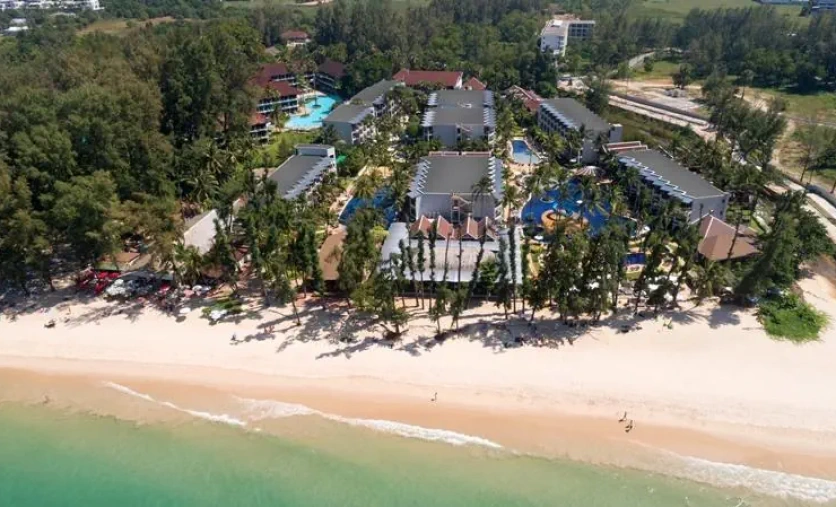 Panoramiczny widok na hotel Sunwing Bangtao Beach z basenami, tropikalną zielenią i szeroką, piaszczystą plażą przy turkusowym morzu