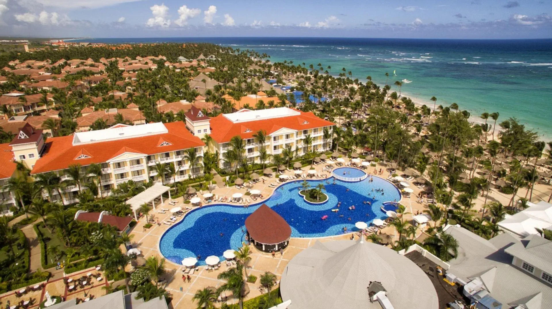 Panoramiczny widok na hotel Bahia Principe Luxury Esmeralda z rozległym basenem, egzotycznymi ogrodami i plażą przy turkusowym oceanie
