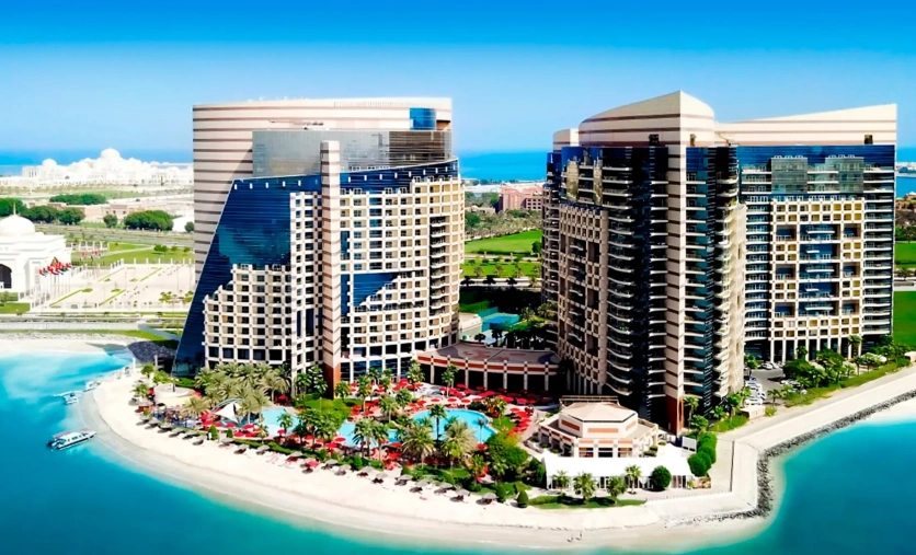 Panoramiczny widok na hotel Khalidiya Palace Rayhaan z prywatną plażą, basenem i nowoczesną zabudową nad turkusową zatoką
