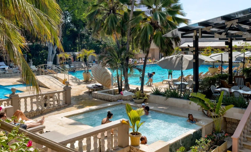 Baseny i strefa relaksu hotelu Caribe By Faranda Grand Radisson Individuals z jacuzzi, palmami i leżakami – Kolumbia, Cartagena