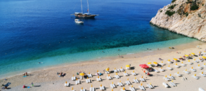 Riwiera Turecka – piaszczysta plaża z leżakami i parasolami przy krystalicznie czystym morzu, idealna na wakacje All Inclusive w Turcji.