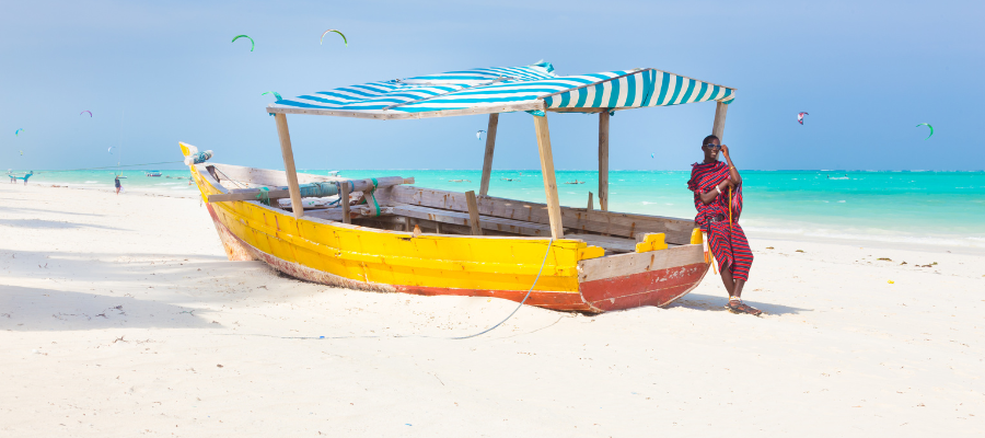 Kolorowa tradycyjna łódź na białej plaży Zanzibar z turkusową wodą oceanu