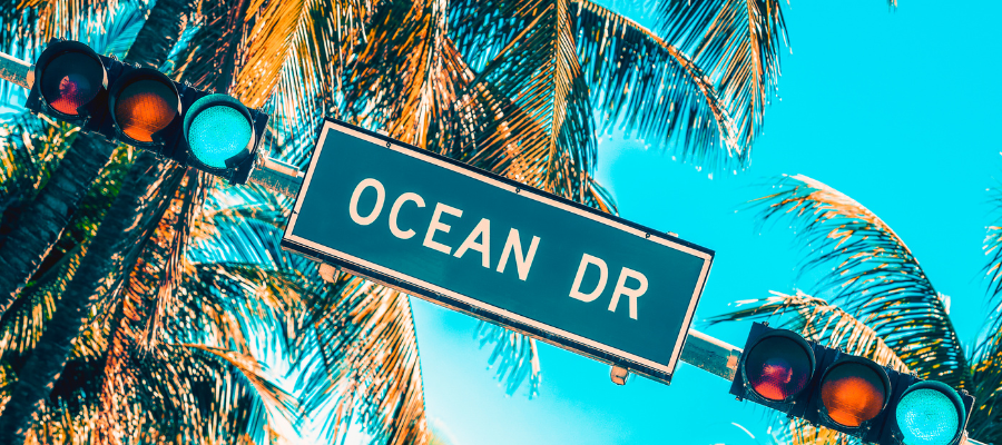 Tablica Ocean Drive w Miami Beach na tle palm i błękitnego nieba