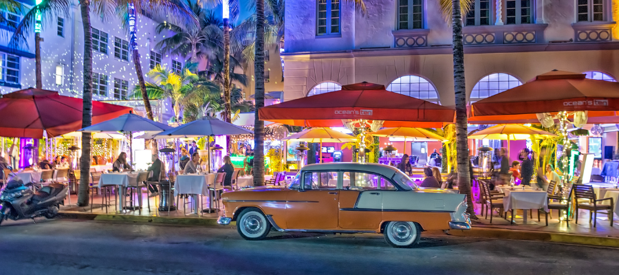 Ocean Drive w Miami nocą z klasycznym amerykańskim samochodem i neonami South Beach