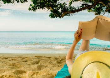 kobieta czytająca książkę na plaży podczas wakacji