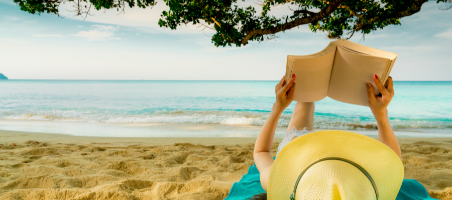 kobieta czytająca książkę na plaży podczas wakacji