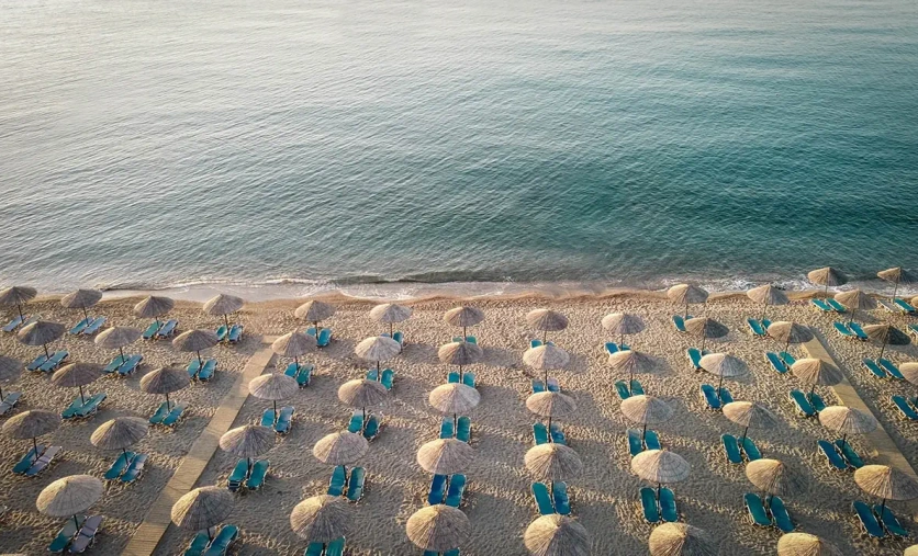Plaża przy hotelu Mitsis Rodos Village na Rodos – leżaki, parasole i wybrzeże Morza Egejskiego